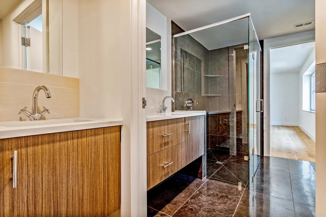 Accessible bathroom with a curbless shower and wood vanity