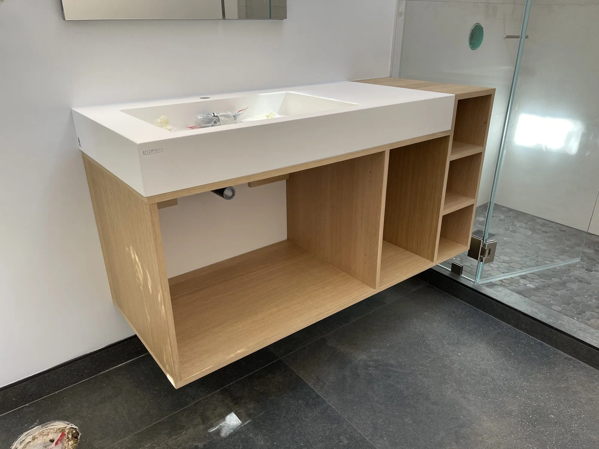 Custom floating vanity with open wood storage