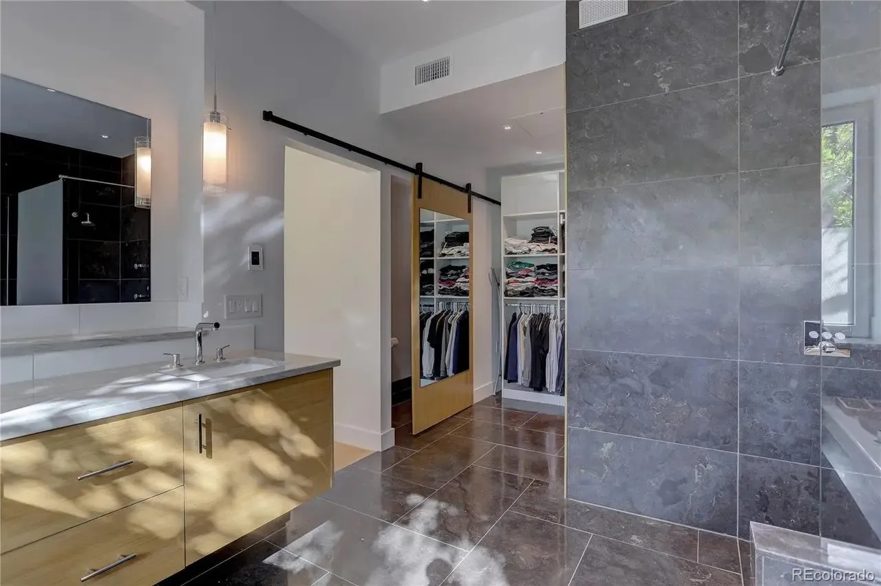 Bathroom opening to a custom closet through a sliding barn door