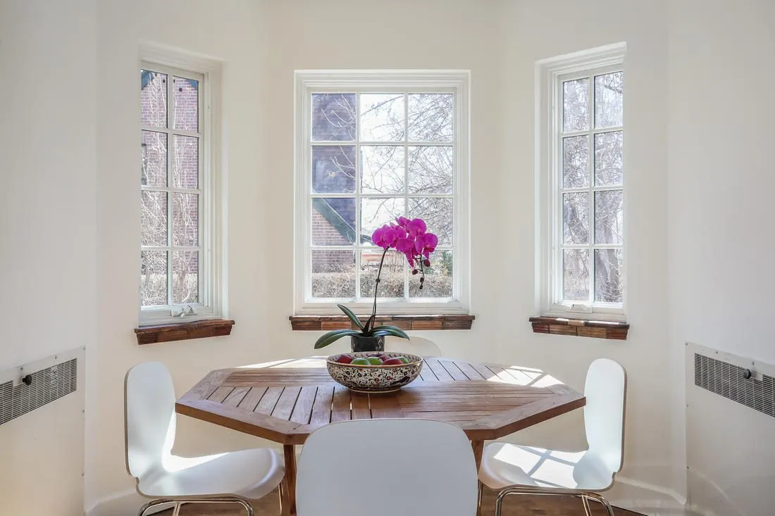 Breakfast nook with a round table under three windows