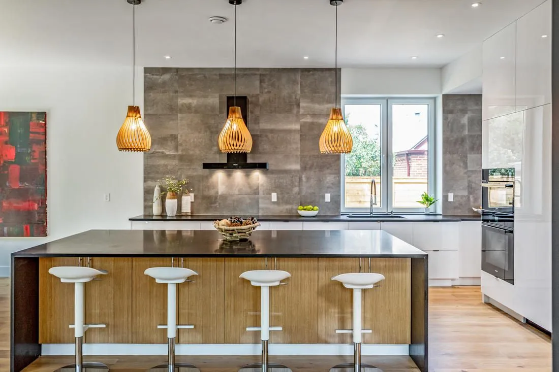 Wood-wrapped island with pendant lights and bar seating