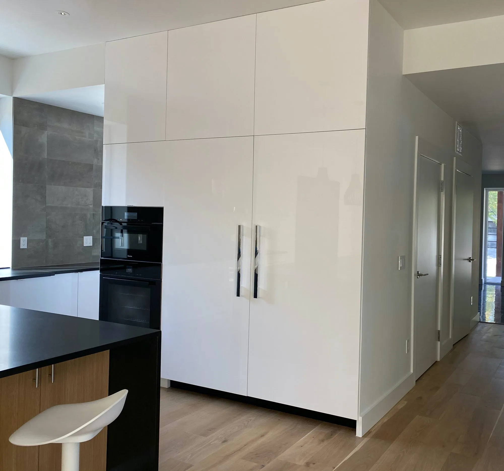Floor-to-ceiling white cabinet wall with integrated appliances