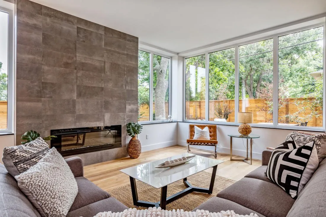 Living room with a linear fireplace and corner windows