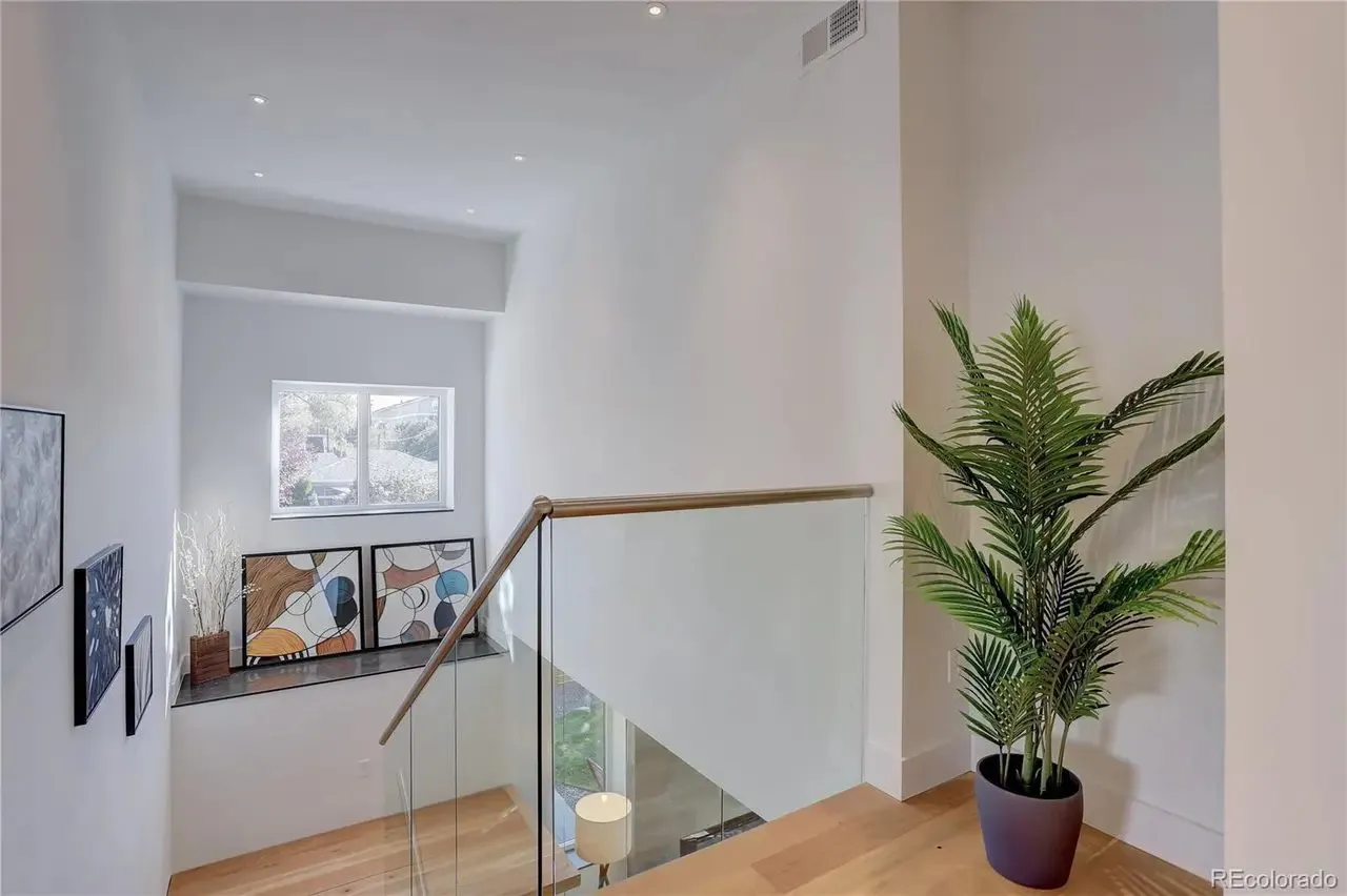 Glass guardrail and wood handrail at an upper landing