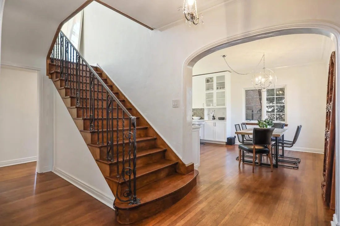 Restored wood staircase with wrought iron balusters in a 1930s home
